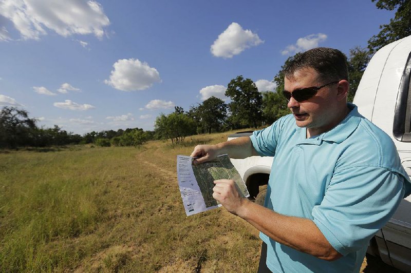 Heath Frantzen uses a map to point out where the proposed natural gas pipeline would cross his 260-acre ranch in central Texas. 