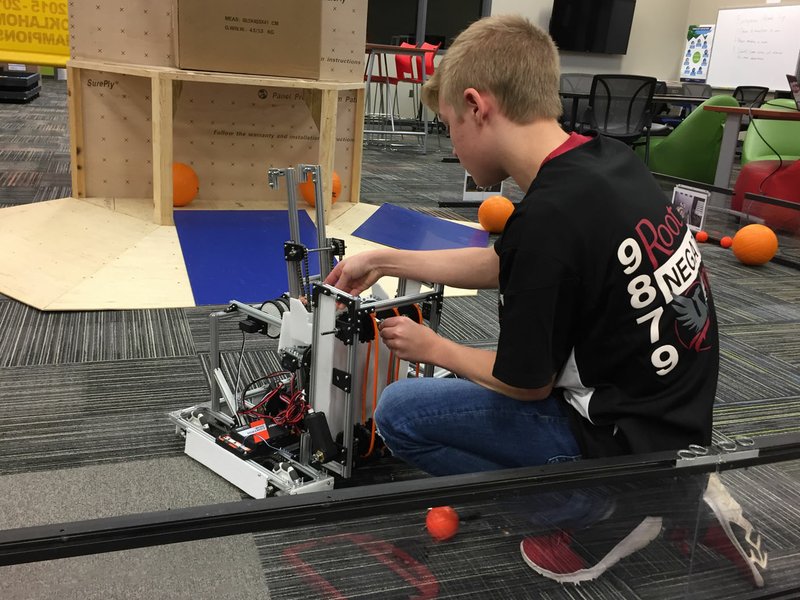 NWA Democrat-Gazette/DAVE PEROZEK Isaac Brown, a member of the robotics team at Tyson School of Innovation in Springdale, tinkers Friday with the robot the team will compete with at the FIRST Global Challenge in Dubai, United Arab Emirates, this week.