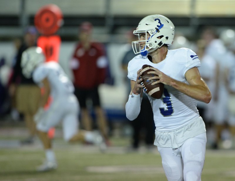 Rogers quarterback Hunter Loyd rolls out to pass Friday, Oct. 4, 2019, during the first half of play against Fayetteville at Harmon Stadium in Fayetteville.