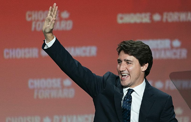 Justin Trudeau waves to the crowd Tuesday in Montreal. “To those who did not vote for us, know that we will work every single day for you, we will govern for everyone,” he said. More photos are available at arkansasonline.com/1023election/ 