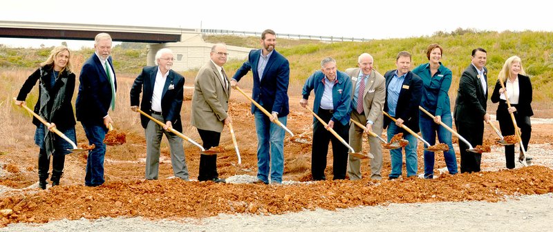 Keith Bryant/The Weekly Vista State and local officials heft up dirt during a groundbreaking ceremony for the last stretch of the Bella Vista Bypass, which will connect Arkansas and Missouri.