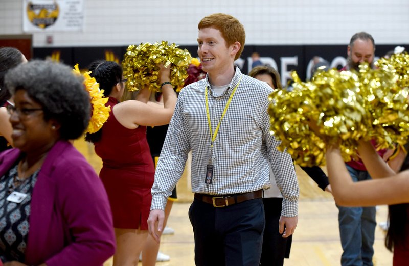 NWA Democrat-Gazette/DAVID GOTTSCHALK Joel Lookadoo walks through the Golden Eagle Cheer and Golden Girls Dance teams Tuesday following a ceremony recognizing him as 2020 Arkansas Teacher of the Year at Lakeside Junior High in Springdale. Lookadoo had spent the past several years as a math teacher at the school.