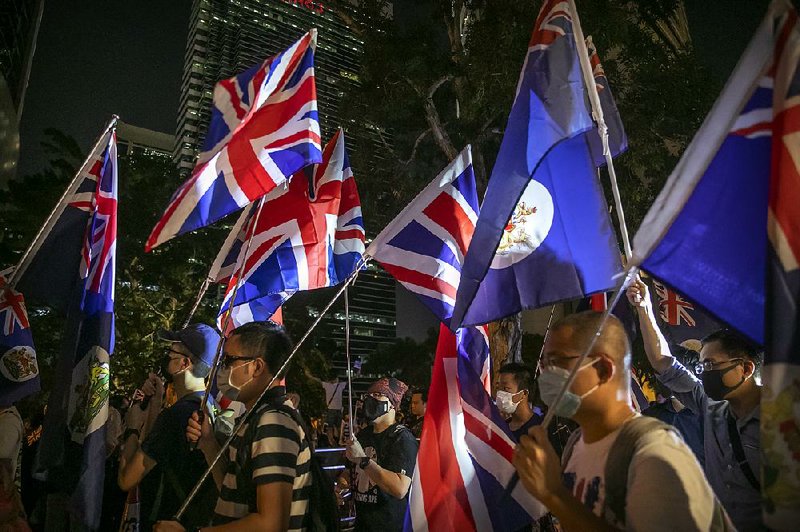 Demonstrators wave colonial flags Wednesday as they march near the British Consulate in Hong Kong. More photos are available at arkansasonline.com/1024hongkong/ 