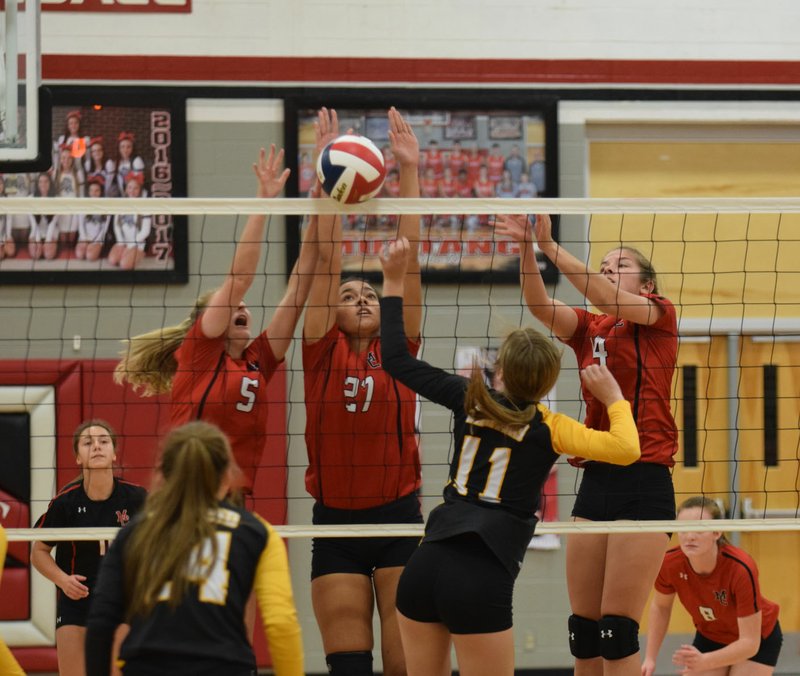 RICK PECK/SPECIAL TO MCDONALD COUNTY PRESS McDonald County's Kelli Brennand, Shye Hardin and Adyson Sanny (back, left) team up for a block on Diamond's Savannah Divine (11) during the Lady Mustangs' 25-19, 22-25, 17-19 loss in pool play of the Lady Mustang Volleyball Classic held on Oct. 19 at MCHS.