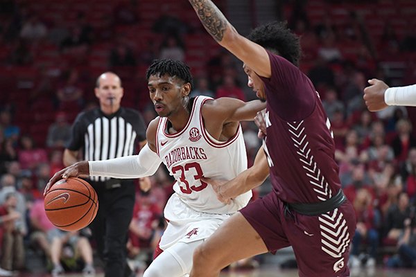 Arkansas guard Jimmy Whitt Jr. drives against Arkansas-Little Rock defender Jaizec Lottie during an exhibition game Sunday, Oct. 19, 2019, in Fayetteville.