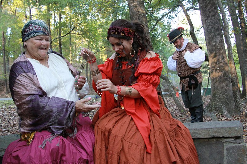From left, Kathy Forman and Alisha Logan, who play gypsies Kat and Zahrina, respectfully, examine a piece of jewelry they stole from Lord Mayor Jacob Twittle, played by Sean Tardif. The Hot Springs Renaissance Faire is scheduled for Saturday and Nov. 3 at the Garland County Fairgrounds in Hot Springs.