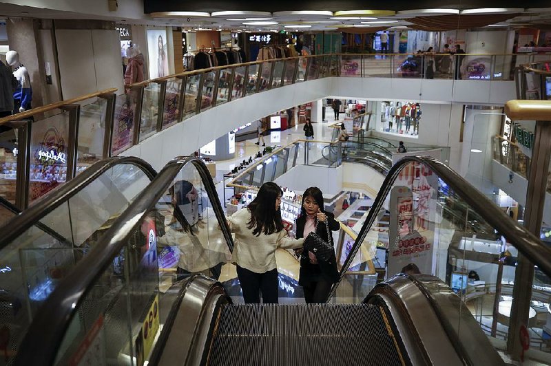 Two women shop earlier this week at an upscale mall in Beijing. The U.S. trade representative’s office said Friday that talks with China’s negotiating team “made headway and the two sides are close to finalizing some sections of the agreement.” 