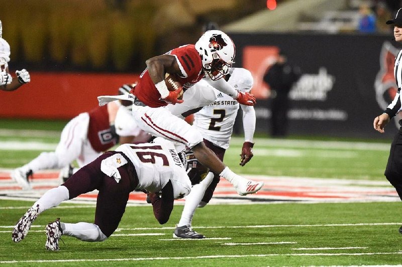 Arkansas State running back Marcel Murray leaps over Texas State safety JaShon Waddy (16) during the Red Wolves’ 38-14 victory Saturday at Centennial Bank Stadium in Jonesboro. Murray ran for 114 yards and 2 third-quarter touchdowns on 22 carries.