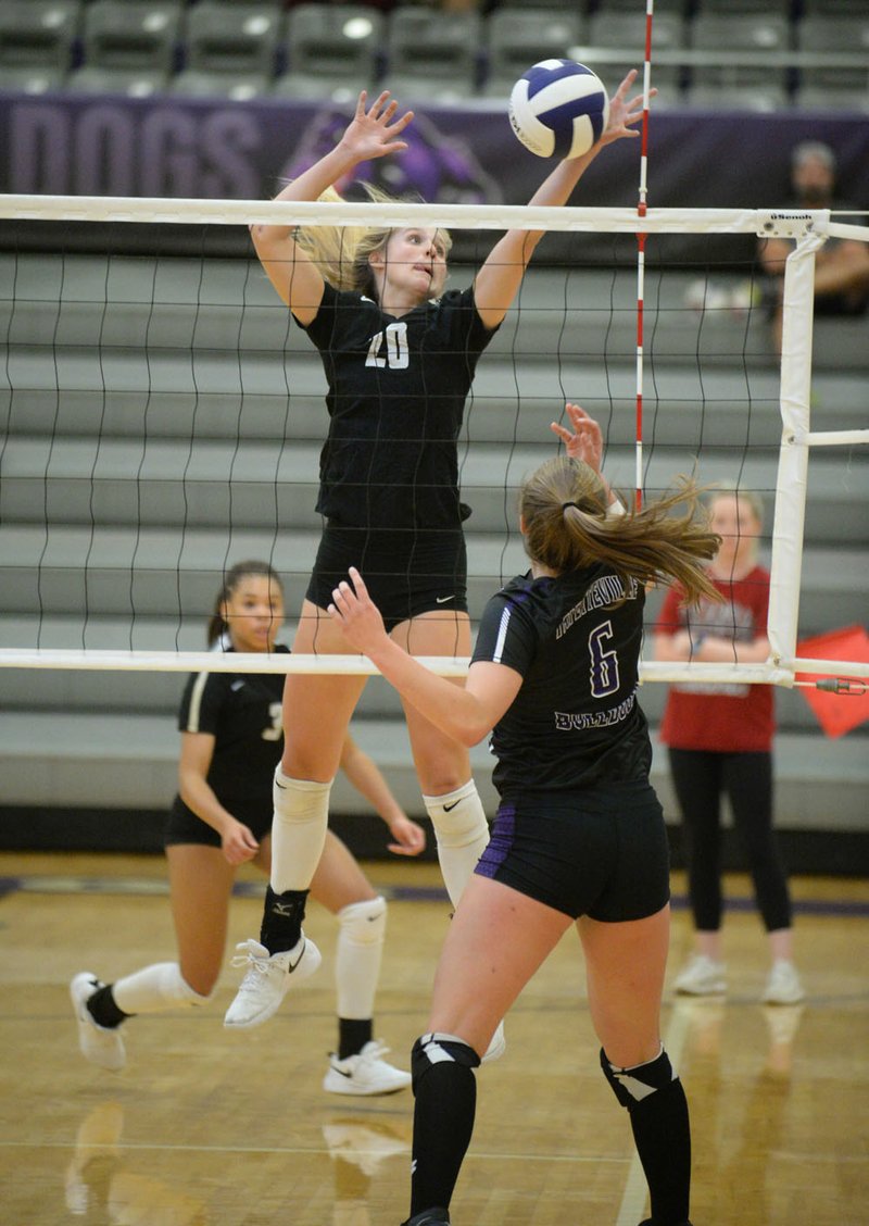 NWA Democrat-Gazette/ANDY SHUPE Bentonville's Savanna Riney (20) redirects a ball tipped by Fayetteville's Perry Flannigan (6) Tuesday, Sept. 17, 2019, during play in Bulldog Arena in Fayetteville. Visit nwadg.com/photos to see more photographs from the match.