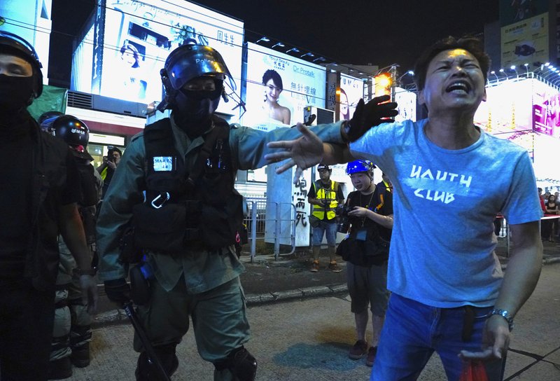 A local resident argues with a police officer in Hong Kong on Saturday, Oct. 26, 2019. Hong Kong authorities have won a temporary court order banning anyone from posting personal details or photos of police officers online, in their latest effort to clamp down on the city's protest movement. (AP Photo/Vincent Yu)