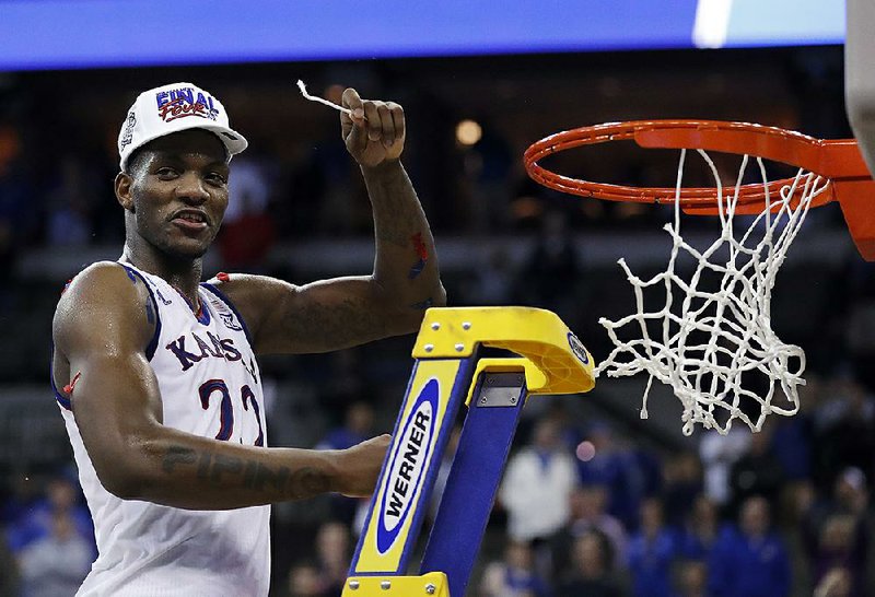 Kansas’ Silvio De Sousa celebrates by cutting down the net after Kansas defeated Duke 85-81 in an NCAA Tournament regional final March 25, 2018, in Omaha, Neb. The Jayhawks program faces serious questions about whether it will remain eligible for the postseason in the wake of NCAA allegations of recruiting fraud involving payments to recruits Billy Preston and De Sousa.