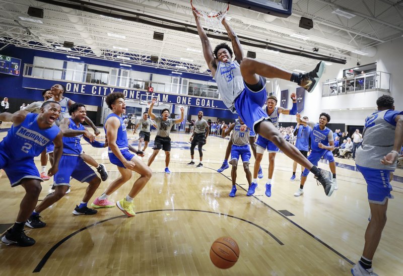 In this Sept. 24, 2019, photo, Memphis center James Wiseman dunks as his teammates celebrate during an open practice for the NCAA college basketball team in front of the Rebounders Club in Memphis, Tenn. Wiseman was selected as a member of The Associated Press preseason All-America team Tuesday, Oct. 22. (Mark Weber/Daily Memphian via AP)