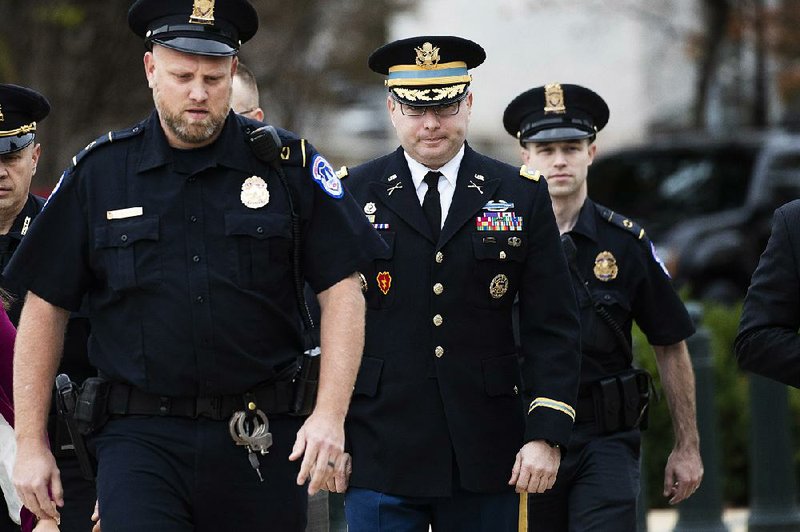 Army Lt. Col. Alexander Vindman (center) heads to a private meeting with impeachment inquiry investigators Tuesday on Capitol Hill. The National Security Council member is the first current White House official to testify before the investigators. 