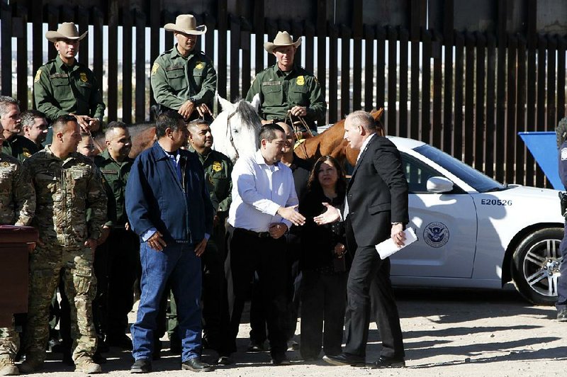 Customs and Border Protection acting Commissioner Mark Morgan (right) shakes hands with members of his staff ahead of a news conference Tuesday near the U.S.-Mexico border in El Paso, Texas. More photos are available at arkansasonline.com/1030border/ 