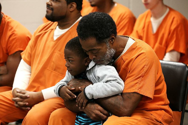 Pulaski County jail inmate Valeto Hendrix hugs his grandson, Dewun Mayo, 4, during a graduation ceremony from the Inside Out Dad program Wednesday. More photos are available at www.arkansasonline.com/1031inout/ 