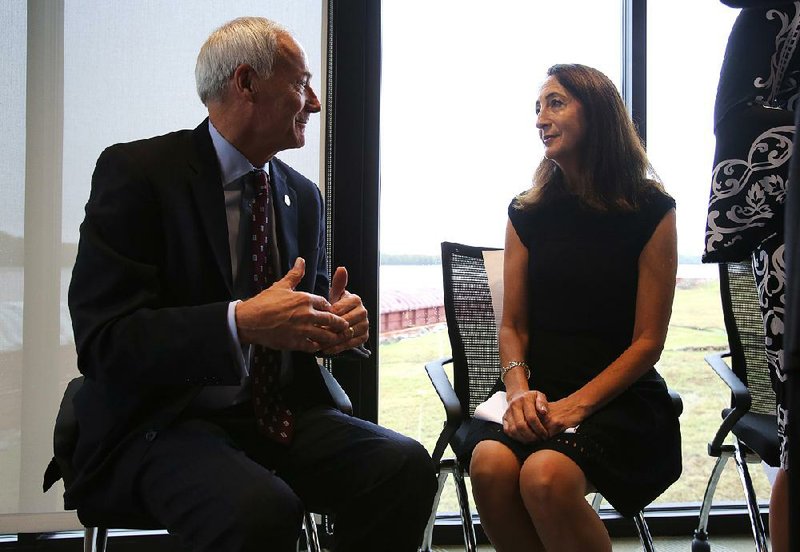 Gov. Asa Hutchinson speaks Wednesday with Janet Sofy, president and chief executive officer of HMS Manufacturing, after the company announced plans to open a manufacturing facility at the Port of Little Rock. 