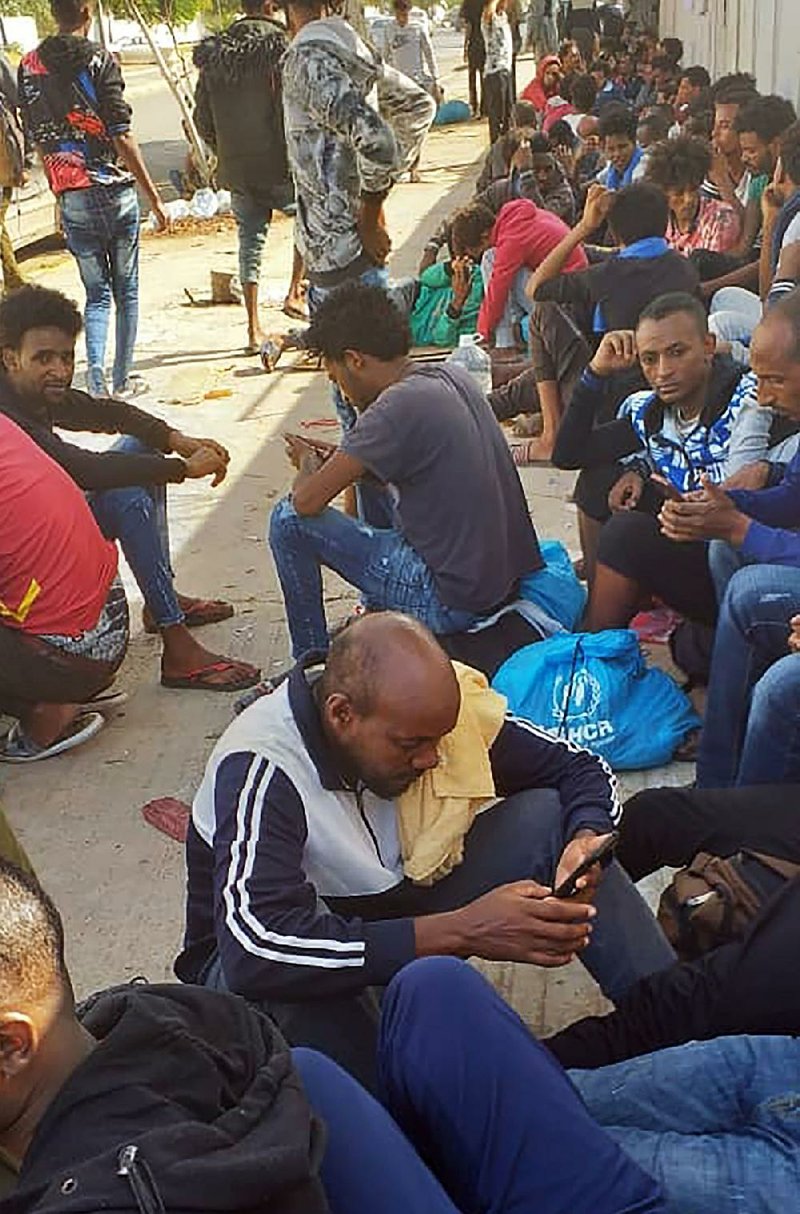 Hundreds of migrants sit Wednesday in a U.N. facility in Tripoli, Libya, after fleeing a coastal detention center. 