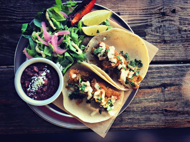 The Fried Fish Taco plate at Mockingbird Bar &amp; Tacos features masa-breaded local striped bass from Arkansas Aquaponics in Lonoke; it's served with tomatillo chow-chow and chipotle crema. Special to the Democrat-Gazette