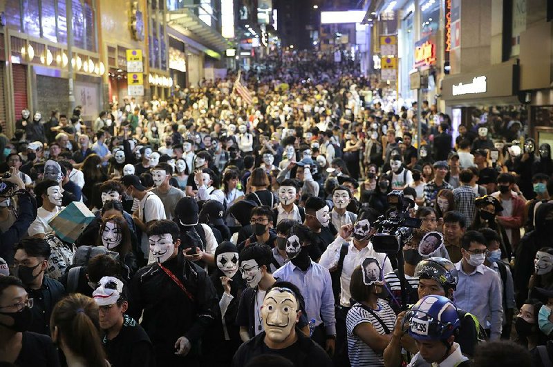 People defy a government ban and wear masks Thursday on a street in Hong Kong. 