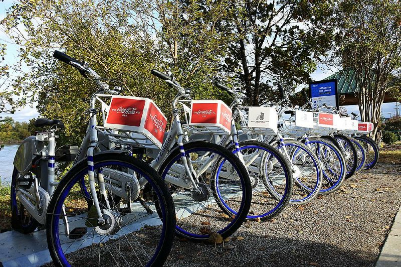 Bicycles stand ready at a bike-share station next to the Riverfront Park Events Building in Fort Smith as part of the “GO FS” Bikeshare Program, which began Thursday. 