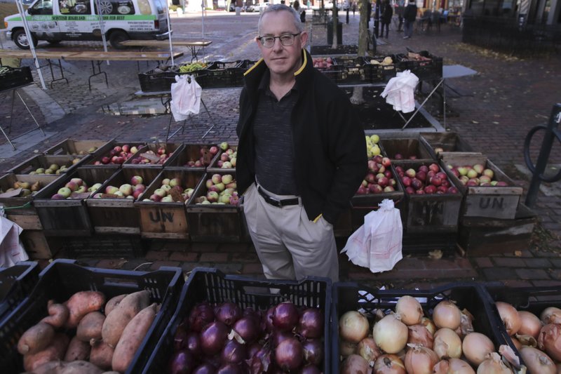 John Gold, self-employed graphics designer, poses at a farmer's market outside his office in Portland, Maine, Wednesday, Oct. 23, 2019. Gold has been covered by the Affordable Care Act since it started, plans on shopping for plans for 2020 again when the enrollment season starts Nov. 1.  (AP Photo/Charles Krupa)
