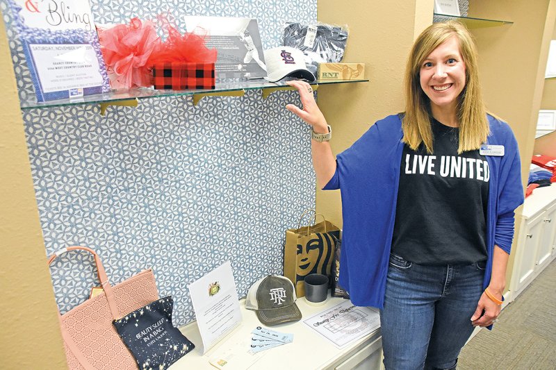 Anne Eldridge, executive director of the United Way of White County, stands next to some of the silent-auction items that will be available during the second Jeans & Bling on Nov. 16 at the Searcy Country Club.