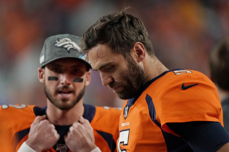 In this Thursday, Oct. 17, 2019 photo, Denver Broncos quarterback Joe Flacco (5) hangs his head as back-up quarterback Brandon Allen looks on during the second half of an NFL football game against the Kansas City Chiefs, in Denver. It took Allen four seasons and three different teams to get his shot at starting in the NFL. The fourth-year pro is taking over with Flacco sidelined by a herniated disk in his neck. (AP Photo/Jack Dempsey)