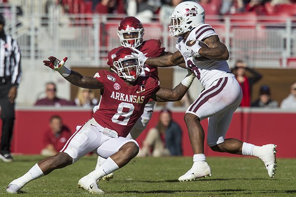 Mississippi State running back Kylin Hill (8, white) stiff arms Arkansas linebacker De'Jon Harris (8, red) during a game Saturday, Nov. 2, 2019, in Fayetteville.