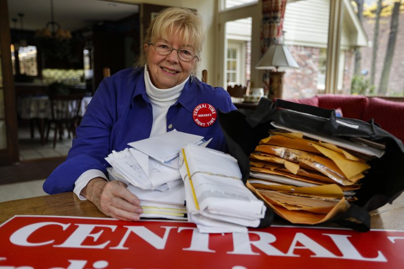 Sue Dillon sits in her home in Carmel, Ind., on Thursday with some of the petitions gathered to change Indiana time zone. Dillon became a campaigner for changes to the state's time choice after a teenager was fatally struck in 2009 while running to catch a school bus in the early morning darkness near her home. - AP Photo/Michael Conroy