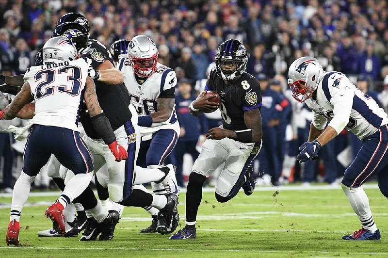 Baltimore quarterback Lamar Jackson cuts through the New England defense during the first half of the Ravens’ victory over the Patriots on Sunday in Baltimore. Jackson passed for 163 yards and 1 touchdown, and ran for 61 yards and 2 more scores in a 37-20 victory.