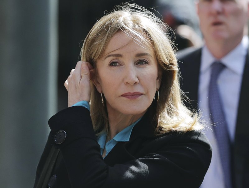 Desperate Housewives star Felicity Huffman arrives at federal court in Boston in April to face charges in the college admissions scandal. She went on to serve 11 days of a 14-day sentence, and now is the subject of a satirical podcast about her time behind bars. (Photo by Charles Krupa via AP)