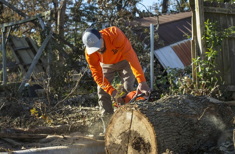 NWA Democrat-Gazette/BEN GOFF @NWABENGOFF
Bryer Calley with T &amp; T Tree Service based in Rogers cuts up a log Friday, Nov. 1, 2019, at a home on West Perry Road in Rogers. The crew is working to clean up damage from an Oct. 21 tornado that tracked across Benton County from Siloam Springs to Avoca. The property next to Rogers High School had fourteen trees fall as well as damage to the roof and outside structures. 