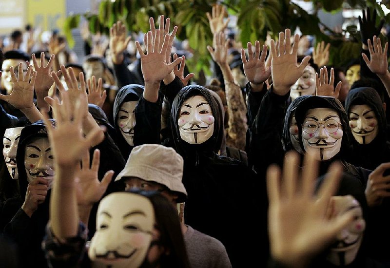 Protesters in Guy Fawkes masks chant slogans Tuesday during a rally in Hong Kong. More photos are available at arkansasonline.com/116china/