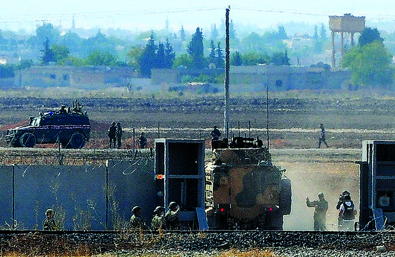 Russian and Turkish forces enter Syria for a joint patrol Tuesday in this photo taken from the outskirts of Suruc in southeastern Turkey. It was the second round of joint patrols for the two countries’ forces. 
