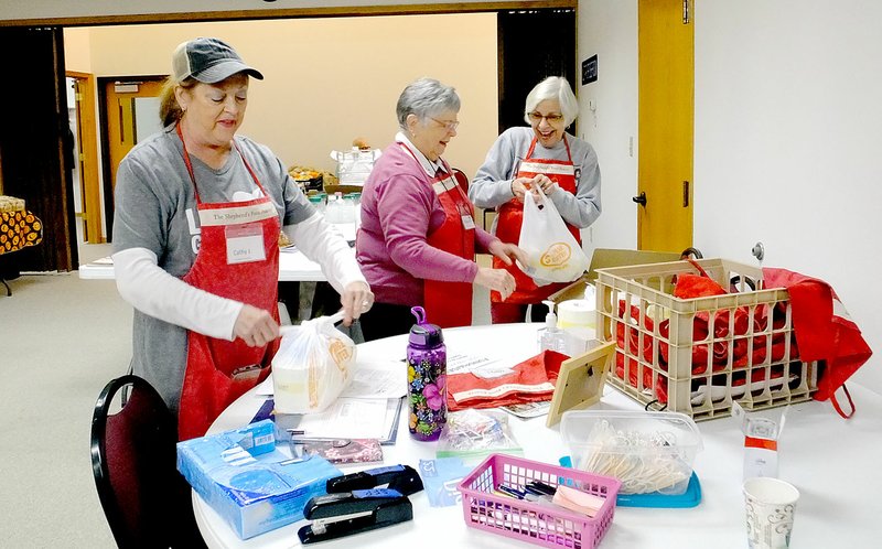 Lynn Atkins/The Weekly Vista Volunteers package some items to be distributed by the Shepherd's Food Pantry at the Bella Vista Lutheran Church last week. Anyone in need can get some groceries and hygiene items at either of the two food pantries run by Bella Vista Churches.