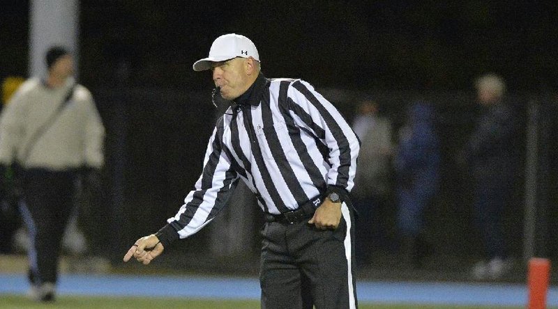 Head official Briant Derrick signals the ball ready for play during Friday’s game between Bryant and North Little Rock. Numbers of officials working in Arkansas have dwindled in recent years. 