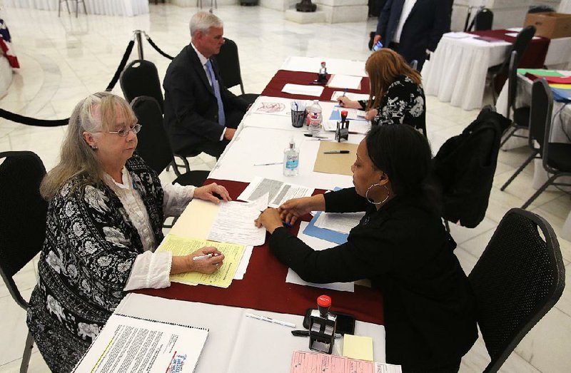 U.S. Rep. Steve Womack, R-Ark., (top left) files for reelection Wednesday at the state Capitol as Lisa Hassell (lower left) files as a Democratic candidate for state House District 68. 