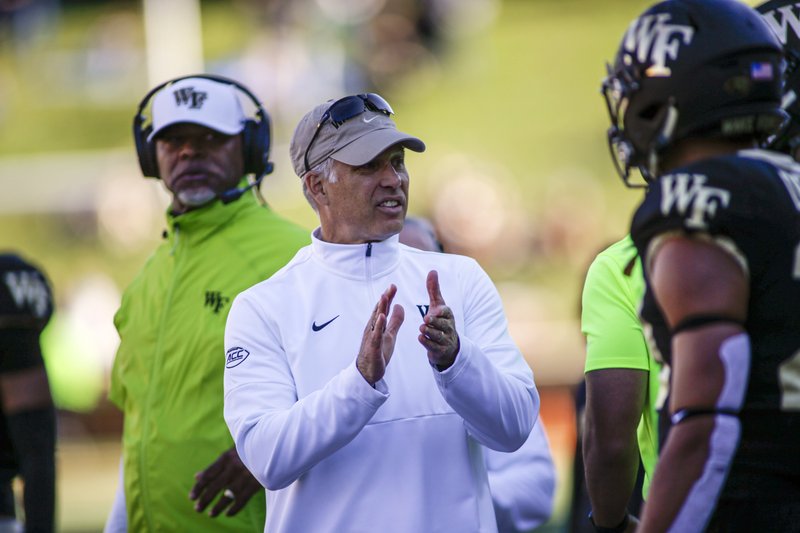 Wake Forest head coach Dave Clawson, center, talks to his team as they play North Carolina State in the second half of an NCAA college football game in Winston-Salem, N.C., Saturday, Nov. 2, 2019. Wake Forest won 44-10. (AP Photo/Nell Redmond)