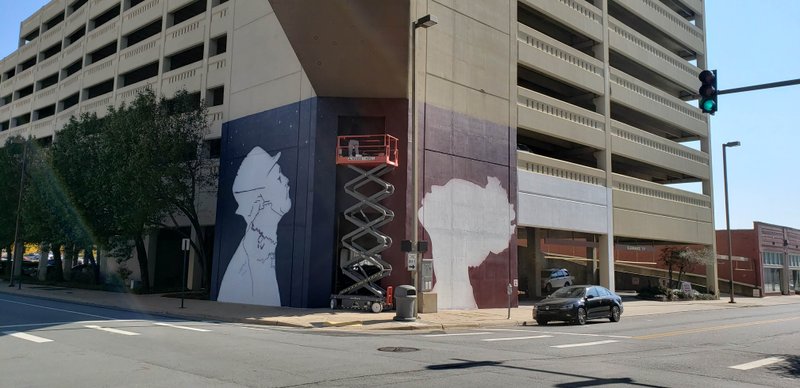 Work continues Tuesday on a mural on the Simmons Tower parking garage at the southeast corner of Sixth and Spring streets.