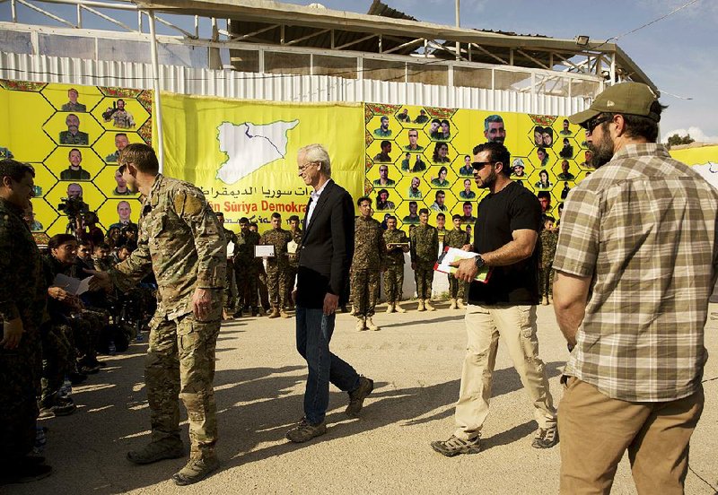 William Roebuck (center), the top U.S. diplomat on the ground in northern Syria, leaves after speaking at a March 23 ceremony at the al-Omar Oil Field base to celebrate the U.S.-backed Syrian Democratic Forces defeat of Islamic State militants in Baghouz. Roebuck criticized the Trump administration in an internal memo for not doing more to stand in the way of Turkey’s operation against U.S. allies in northern Syria. 