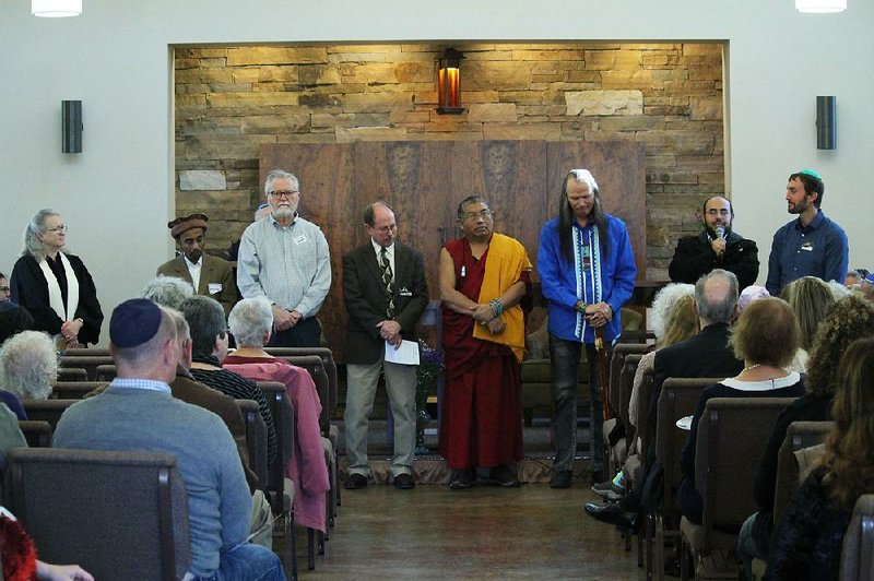 Imam Abdellah Essalki (second from right) gives a blessing during the celebration of Temple Shalom’s 10th anniversary in Fayetteville on Sunday. Faith community members also giving blessings were (from left) the Rev. Georgia Senor, Dr. Hameed Naseem, John Babbs, the Rev. Jim Parrish, Geshe Thupten Dorjee, John Two Hawks and the Rev. Clint Schnekloth. Fayetteville Mayor Lioneld Jordan also spoke at the gathering. 