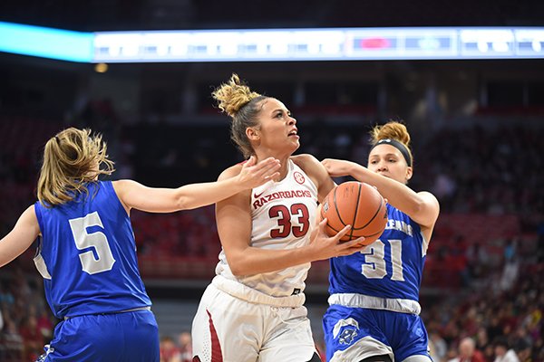 Arkansas' Chelsea Dungee (33) goes up for a shot at New Orleans' Asia Woods (31) and Traya Bruce (5) defend during a game Friday, Nov. 8, 2019, in Fayetteville.