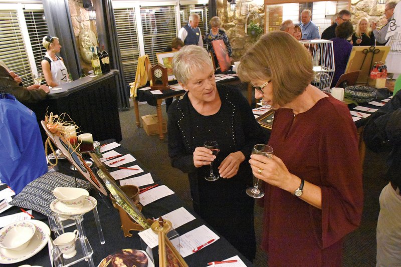 Katie Crumby, left, of Melbourne and Jennifer Blankenship of Mount Olive talk while checking out the auction items during the Arkansas Craft School Gala last year. This year’s gala will take place Nov. 21 at the Skillet Restaurant at the Ozark Folk Center in Mountain View.