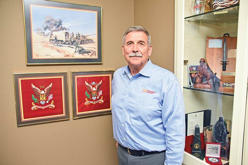 Retired Army Maj. Gen. William David Wofford displays some of his favorite military memorabilia at his home in Conway. Among the items are a painting depicting the Arkansas artillery units of the 142nd Field Artillery Brigade during Operation Desert Storm, above, and flag replicas of the two field artillery units he commanded during Operation Desert Storm — the 5th Battalion, 206th Field Artillery, and the 2nd Battalion, 142nd Field Artillery.