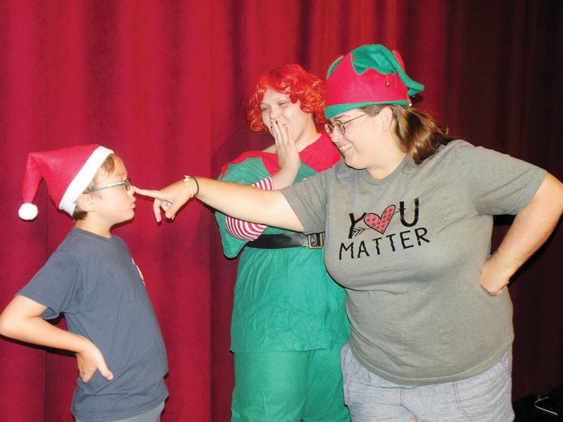 Mistletoe Merryman, second from left, played by Amanda Autry, and Holly Daze, right, played by Irene Taylor, portray elfin hosts for the talent show in North Pole’s Got Talent. They work with Coal, played by Johnny Bertram, who is the keeper of the “naughty and nice” list for Santa and stage manager of the talent show in the upcoming production at the Rialto Community Arts Center. story.lead_photo.caption