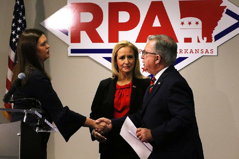 Sarah Huckabee Sanders (left) and Arkansas Attorney General Leslie Rutledge (center) submit paperwork to state Republican Party Chairman Doyle Webb at party headquarters in Little Rock on behalf of President Donald Trump. 