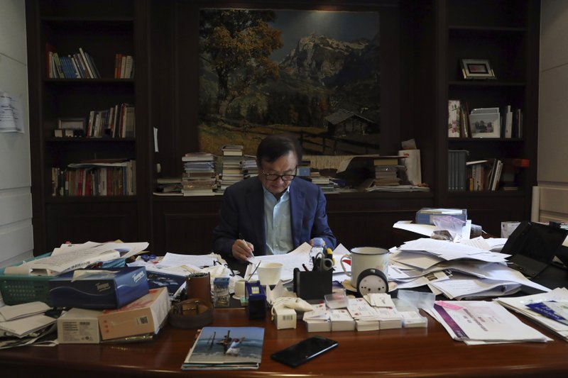 In this Aug. 20, 2019, photo, Huawei's founder Ren Zhengfei reads documents in his office at the Huawei campus in Shenzhen in Southern China's Guangdong province. Ren says its troubles with President Donald Trump are hardly the biggest crisis he has faced while working his way from rural poverty to the helm of China&#x2019;s first global tech brand. (AP Photo/Ng Han Guan)