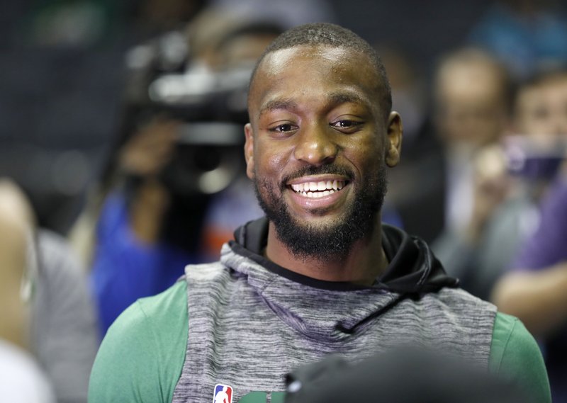 The Associated Press HOMECOMING: Boston Celtics' Kemba Walker smiles with friends as he makes his way onto the Charlotte Hornets' court Thursday before an NBA basketball game between the Celtics and the Hornets in Charlotte, N.C. Walker formerly played for the Hornets.