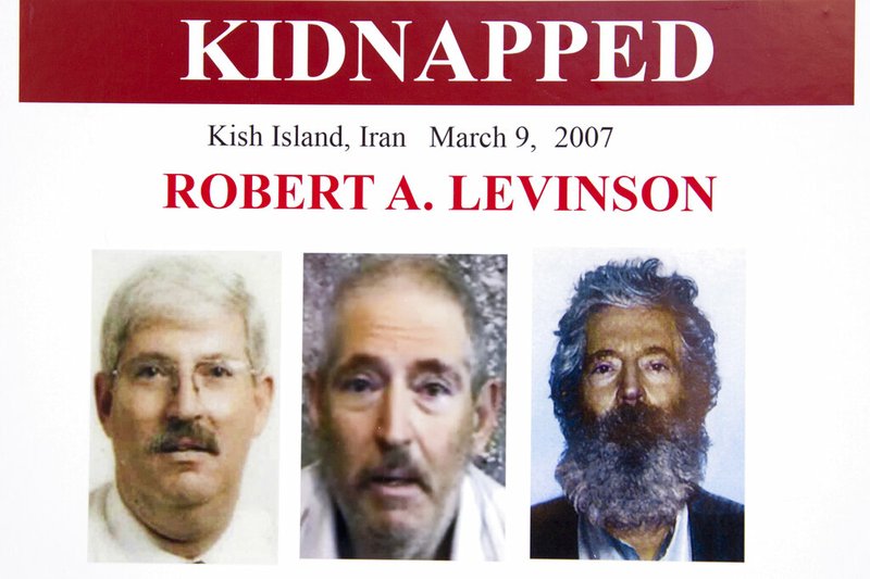 FILE - In this March 6, 2012, file photo, an FBI poster showing a composite image of former FBI agent Robert Levinson, right, of how he would look like now after five years in captivity, and an image, center, taken from the video, released by his kidnappers, and a picture before he was kidnapped, left, displayed during a news conference in Washington.