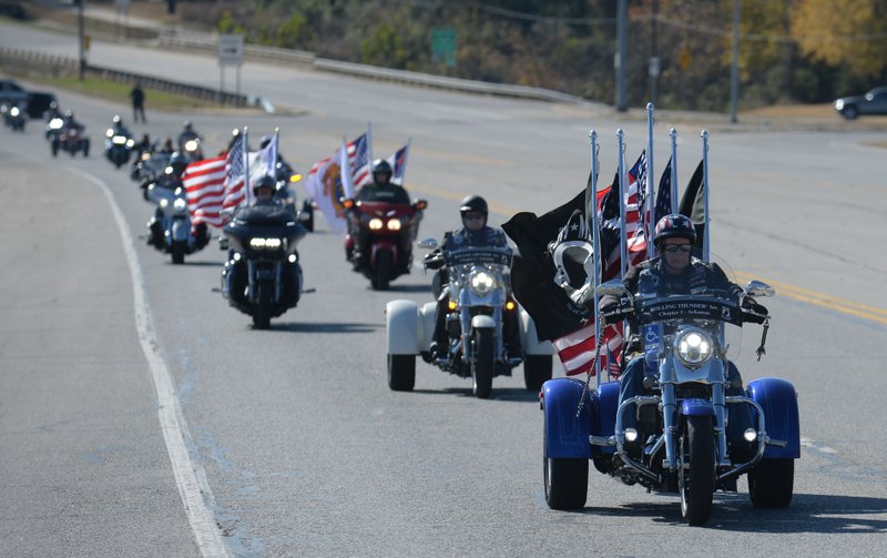 A long line of motorcycles makes its way north on College Avenue Saturday, Nov. 9, 2019, at the start of a Veterans Day parade and ride organized by Pig Trail Harley-Davidson beginning at Lokomotion Family Fun Park in Fayetteville. The annual ride serves as a fundraiser for the Disabled American Veterans nonprofit.